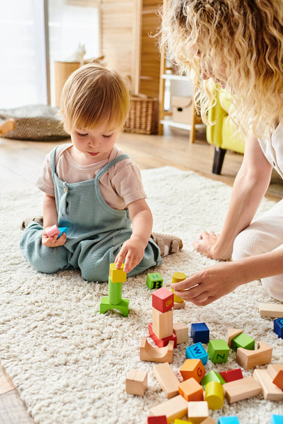 Kıvırcık saçlı anne, evde Montessori eğitim yöntemini kullanarak küçük kızıyla sevgi dolu bir ilişki kuruyor.. - Fotoğraf, Görsel