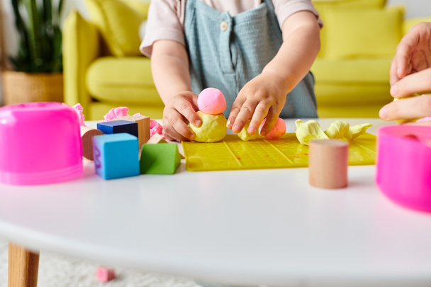 Een moeder begeleidt haar kleine meisje door Montessori leren met kleurrijke blokken en vormen. - Foto, afbeelding