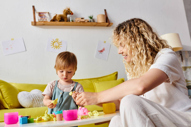 Kıvırcık bir anne ve küçük kızı evde Montessori eğitim yöntemini kullanarak eğlenceli bir öğrenim görürler.. - Fotoğraf, Görsel