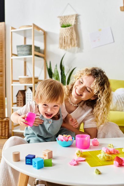 A curly mother and her toddler daughter playing with Montessori educational toys at home, fostering creativity and learning. - Photo, Image