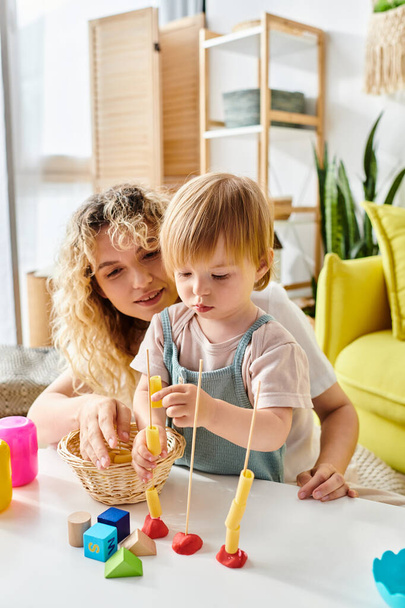 Een krullende moeder en haar peuterdochter spelen graag met speelgoed, beoefenen de Montessori methode van onderwijs thuis. - Foto, afbeelding