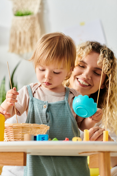 Egy göndör anya és kislánya Montessori-ihletésű játékokkal játszik otthon, elősegítve a kreativitást és a tanulást.. - Fotó, kép