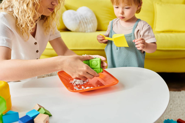 Una madre dai capelli ricci coinvolge sua figlia nel gioco Montessori, favorendo l'apprendimento e la gioia nel loro accogliente soggiorno.. - Foto, immagini