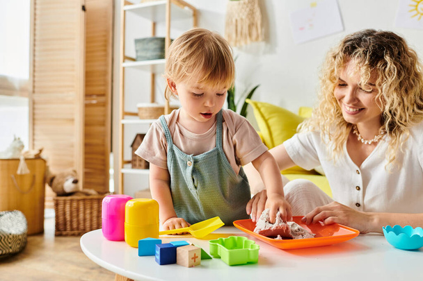 Кучерява мати та її дочка-малюк щасливо граються з іграшками Монтессорі вдома, сприяючи творчості та навчанню.. - Фото, зображення