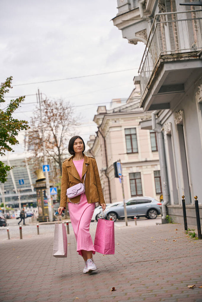 Modelo bonito fêmea andando com sacos de compras comprando roupas em lojas na rua da cidade - Foto, Imagem