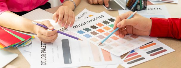 Kreative Interior Designer Brainstorming über die Farbe des Materials. Gruppe von Architekten Designer wählen Farbe sorgfältig durch Verwendung von Farbmustern. Kreatives Design und Teamwork-Konzept. Bunt gemischt. - Foto, Bild