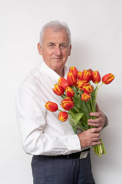 Viejo guapo con un ramo de tulipanes. - Foto, imagen