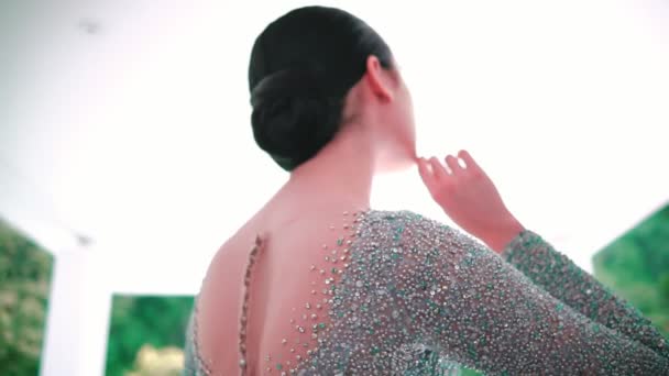 Κομψό γυναίκα σε ένα glittery φόρεμα σε εξωτερικούς χώρους, γκρο πλαν στην πίσω λεπτομέρεια με φυσικό υπόβαθρο κατά τη διάρκεια της ημέρας - Πλάνα, βίντεο