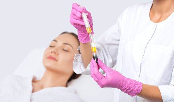 Kosmetikerin macht Prp-Therapie auf dem Gesicht einer schönen Frau in einem Schönheitssalon. Kosmetologie-Konzept. - Foto, Bild