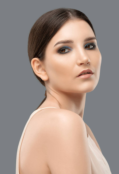Portret van een aantrekkelijk meisje met een gezonde schone huid en mooie make-up. Esthetische kosmetologie en make-up concept. - Foto, afbeelding