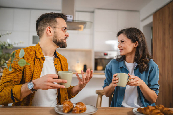 Aikuinen pari on aamiainen ja kuppi kahvia kotona aamulla rutiini - Valokuva, kuva