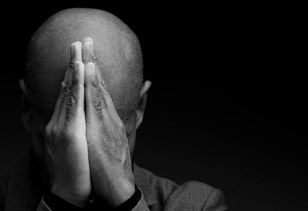 Caribische man biddend tot god met handen bij elkaar, zwart-wit studiofoto - Foto, afbeelding