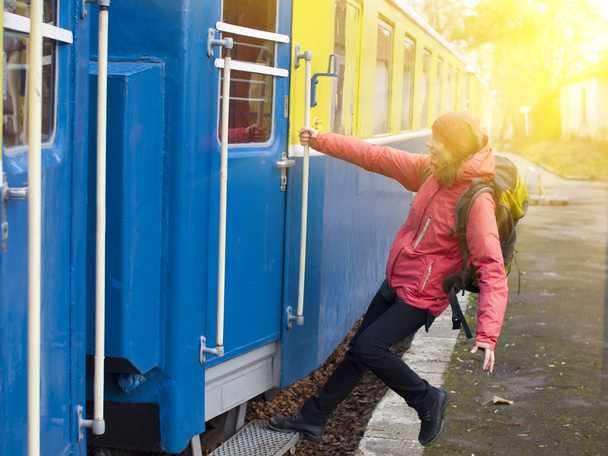 The girl jumps into the train. - Foto, afbeelding