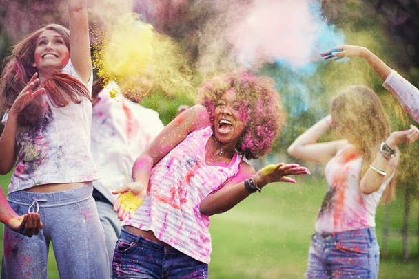 Φίλοι, ευτυχία και πούδρα χρώμα στο φεστιβάλ χρωμάτων στο πάρκο, διασκέδαση με γιορτή ή πάρτι υπαίθρια. Ελευθερία, δέσιμο και πολύχρωμο χάος στη φύση, χαρά και κουλτούρα με τους ανθρώπους στην καλοκαιρινή εκδήλωση. - Φωτογραφία, εικόνα