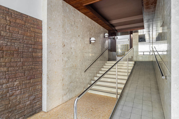 長い廊下のある家の入口,障害者の車椅子,煉瓦および傾いた壁,金属の郵便箱のためのランプが付いているエレベーター区域への階段 - 写真・画像
