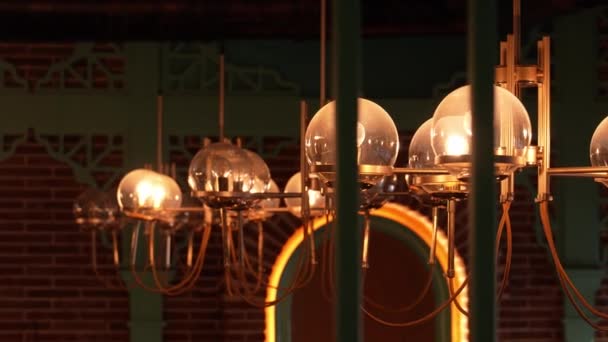 Interiér kavárny s klasickými žárovkami Dekorativní starožitné zářící žárovky ve stylu Edison na pozadí cihlové stěny. retro dekorativní lampa. - Záběry, video