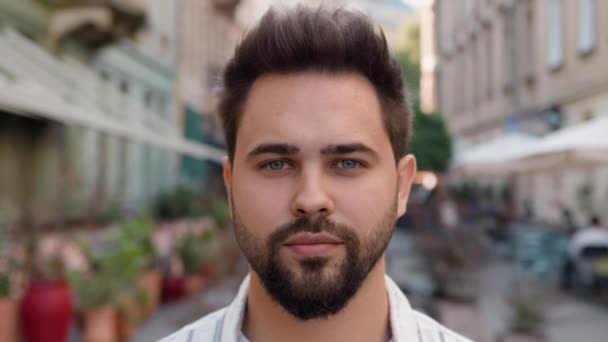 Yakın plan Avrupalı beyaz adam kamera şehrine bakıyor sokak iş adamı gen z erkek sakallı yakışıklı adam kentsel model sakin odaklı ciddi ifade - Video, Çekim