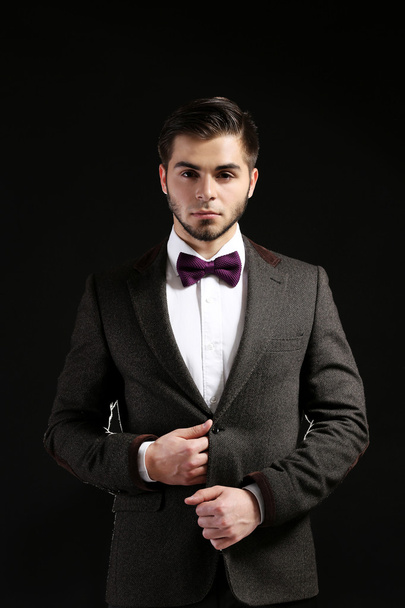 eleganter Mann im Anzug auf dunklem Hintergrund - Foto, Bild