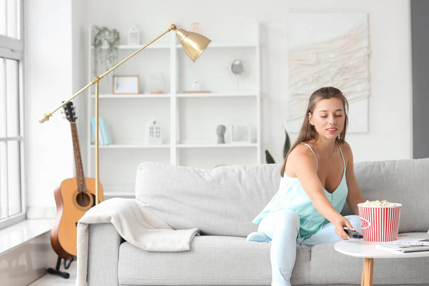 Mladá žena se dívá na televizi, když má doma volno - Fotografie, Obrázek