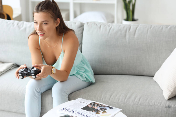 Młoda kobieta grająca w gry wideo w wolny dzień w domu - Zdjęcie, obraz
