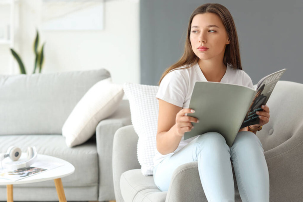 Молодая женщина читает журнал в свой выходной дома - Фото, изображение