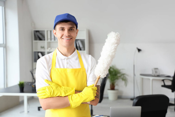Trabajador masculino de servicio de limpieza con pp-duster en oficina - Foto, Imagen
