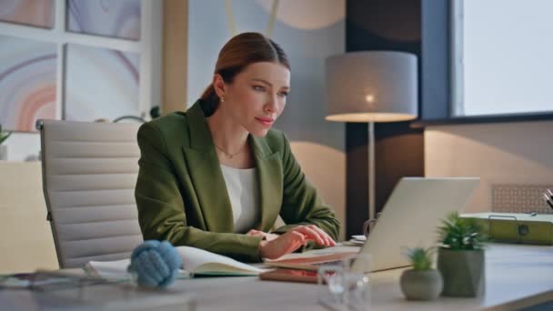 Захоплена жінка читає чудові новини на екрані ноутбука, сидячи в розкішному офісі крупним планом. Керівник молодої бізнес-леді радіє діловим досягненням, висловлюючи щастя на робочому місці. Концепція успіху роботи - Кадри, відео
