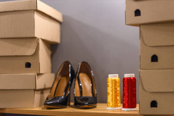 Kierrepuolat, joissa on kenkälaatikoita hyllyllä suutarin työpajassa, lähikuva - Valokuva, kuva