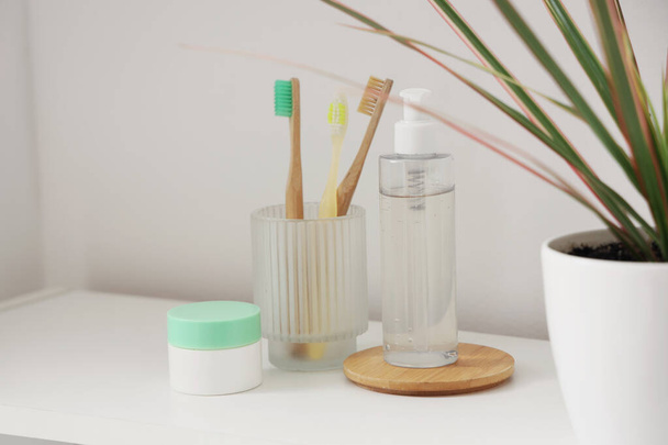 Spazzolini da denti con prodotti per la cura della pelle sul tavolo in bagno, primo piano - Foto, immagini