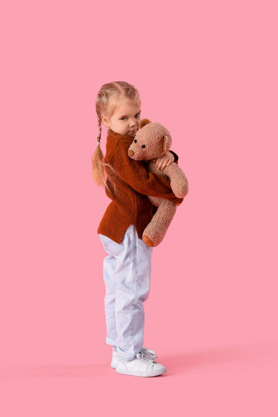 Menina com transtorno autista e urso de brinquedo no fundo rosa - Foto, Imagem