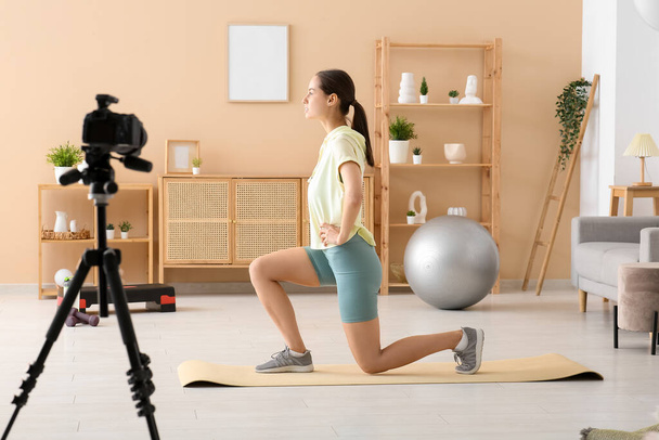 Αθλητική γυναίκα blogger άσκηση και καταγραφή βίντεο στο σπίτι - Φωτογραφία, εικόνα