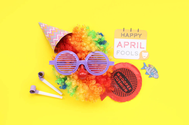 Klaun paruka s legračními brýlemi, party dekor a slavnostní pohlednice pro duben Blázni den na žlutém pozadí - Fotografie, Obrázek