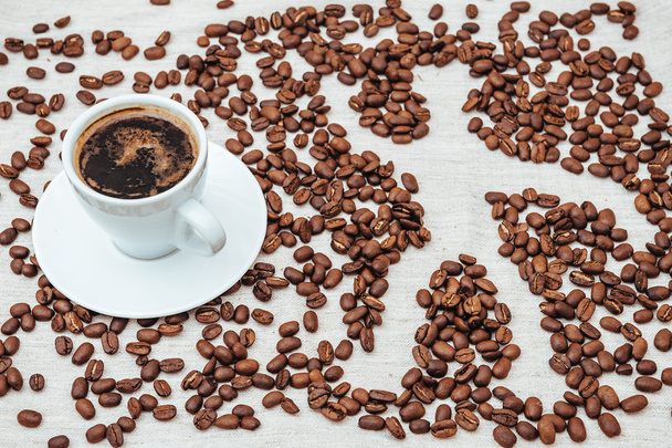 Tasse Kaffee und Bohnen auf beigem Hintergrund mit menschlichen - Foto, Bild