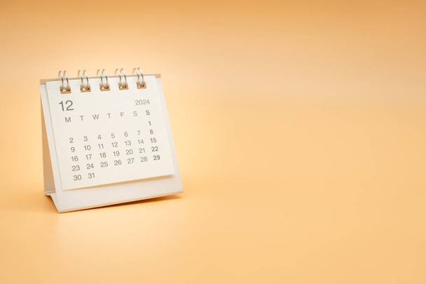 Yksinkertainen työpöytä kalenteri joulukuun 2024 eristetty oranssi tausta. Kalenteri käsite kopioi tilaa. - Valokuva, kuva