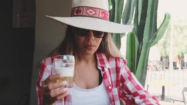 Kobieta pije piwo i uśmiecha się Portret pięknej młodej kobiety pijącej piwo i cieszącej się letnim dniem - Materiał filmowy, wideo