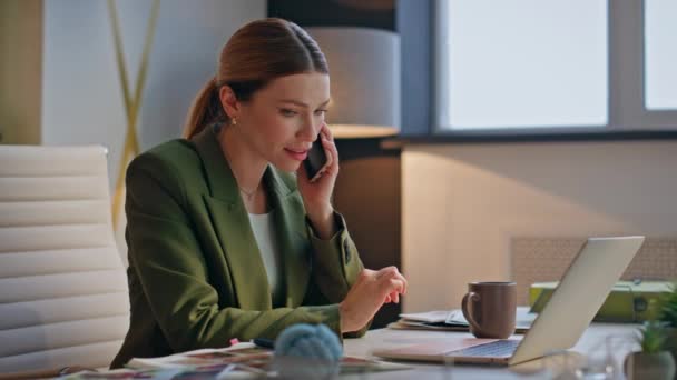 Financial manager talking smartphone at desk closeup. Young businesswoman working laptop calling partner in modern creative office. Corporate employee speaking consulting client on mobile phone call - Footage, Video