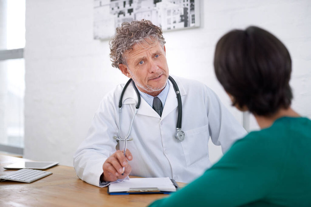 Medical, consultation and mature doctor with a checklist for healthcare, insurance or results of test. Clinic, patient and man in discussion of surgery or exam and professional paperwork for hospital. - Photo, Image