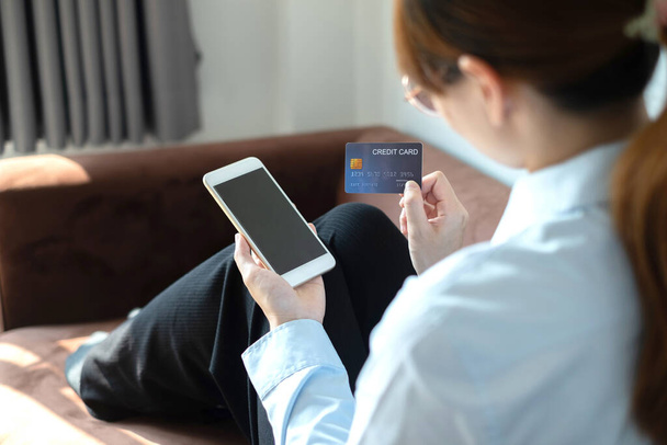 Ázsiai lány online vásárlás gazdaság hitel és az okostelefon segítségével adja meg a kártya számát a mobiltelefon app vásárolni és fizetni internetes áruház. - Fotó, kép