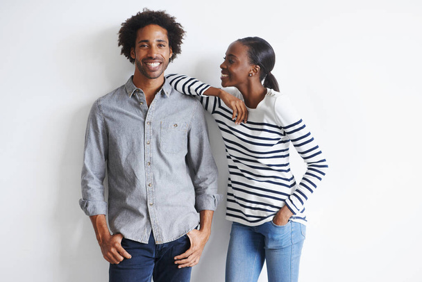 Couple, hug and portrait by white wall in fashion with confidence, casual style and model aesthetic. Black woman, and face of man with trendy apparel, edgy clothes and happiness with relax or romance. - Valokuva, kuva