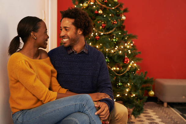 Noel, aşk ve siyahi çift tatilde ya da tatilde mutlulukla el ele tutuşuyorlar. Kutlama, ağaç ve insanlar evde özenle ve destekle kucaklaşır ya da birlikte kutlamaya can atarlar.. - Fotoğraf, Görsel