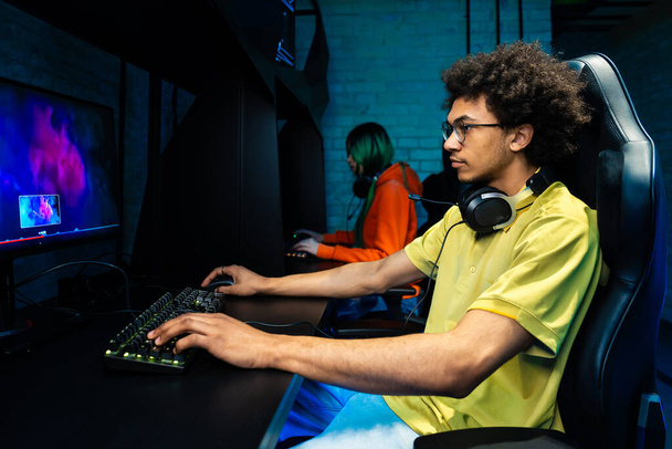 Multiethnic group of young friends playing videogames - Team of professional esport gamers playing in competitive video games on a cyber games tournament - Fotó, kép
