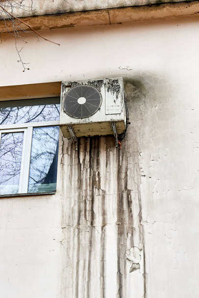 the external unit of the air conditioner on the wall of the house with streaks of dirt from precipitation - Photo, Image