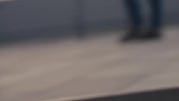 Κοντινό πλάνο ενός ατόμου πόδια σε κόκκινο sneakers σε ένα skateboard, πλεύσης κατά μήκος ενός τσιμεντένιου πεζοδρομίου με θολή αστικό υπόβαθρο. Ξέγνοιαστη έφηβος κορίτσι ιππασία ένα longboard στην προκυμαία - Πλάνα, βίντεο
