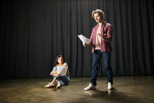 Κομψός άντρας και γυναίκα στέκονται μαζί σε μια θεατρική σκηνή. - Φωτογραφία, εικόνα