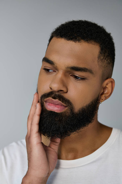 Close up of a appelaing young man grooming his beard. - Photo, Image