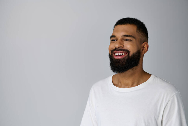 Uomo sorridente con la barba in camicia bianca, godendo di routine di cura della pelle. - Foto, immagini