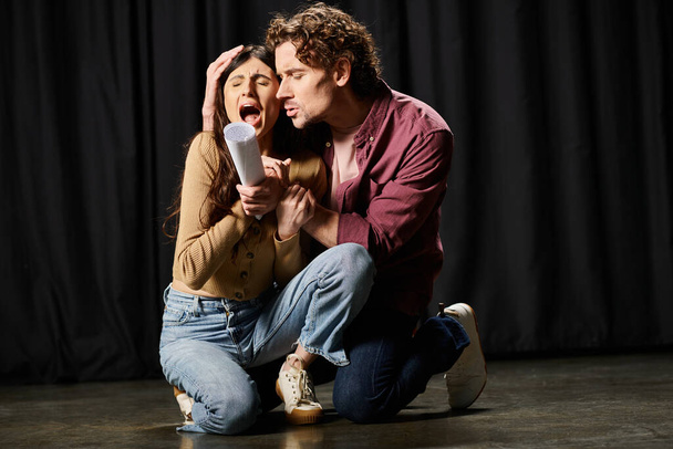 El hombre se arrodilla junto a la mujer, actuando durante el ensayo teatral. - Foto, Imagen