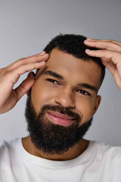 Afričan americký mladý muž s plnovousem starat se o jeho vlasy. - Fotografie, Obrázek