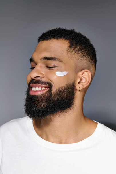 African american handsome man with a beard showcasing white cream on his face. - Photo, Image