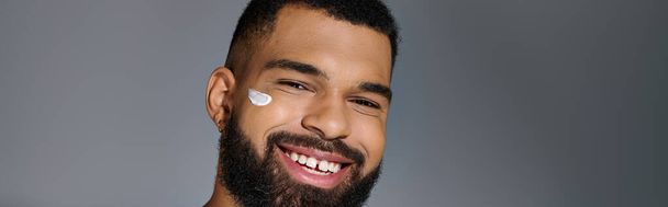 Handsome young man with a beard performing skincare routine. - Photo, Image